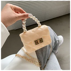 Detail of a mini jelly bag featuring a pearl handle, gold twist lock, and quilted texture
