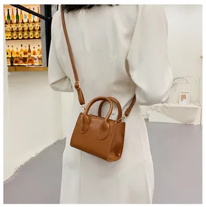 Brown mini square bag shown on model back view in a stylish bar setting