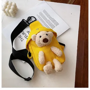 Detalle del bolso bandolera de lona amarilla con osito de peluche 3D y correa ajustable