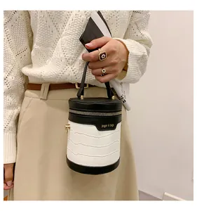 Detail einer Mini-Zylinder-Beuteltasche mit schwarz-weißem Krokodilmuster-Design