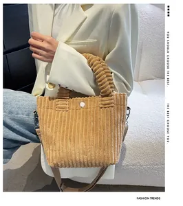 Brown corduroy bucket bag detail showing vertical texture and adjustable shoulder strap