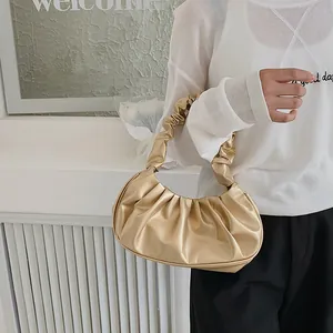 Detalle del bolso nube oro champán mostrando los pliegues y la textura del asa fruncida