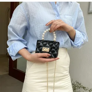 Mini black quilted pearl handle bag with shiny faux leather and gold chain strap