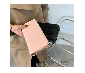 Detail showing pink and black long wallets with crocodile pattern and metal zippers