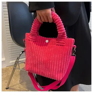 Detailed texture of rose pink corduroy handbag with pleated handle and silver metal hardware