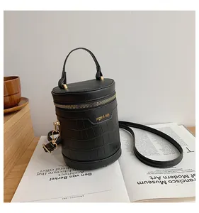 Details der schwarzen Kroko-Zylindertasche mit goldenem Reißverschluss auf Magazin