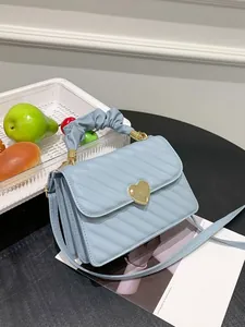 Detailed side view of the blue quilted handbag featuring three-tier accordion structure