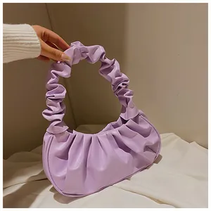 Detalle del bolso nube lavanda que muestra la textura de cuero plisado y el asa suave