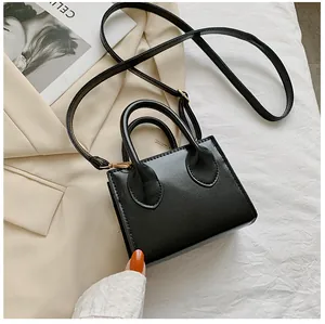 Detailed top view of black mini square bag with golden hardware and leather texture