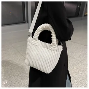 Detail of white corduroy tote bag featuring pleated texture and bubble handle style