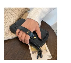 Detail showing women long wallet with black crocodile texture and double zipper feature