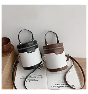 Detailansicht der stylischen zweifarbigen Zylindertaschen mit Krokodil-Prägung