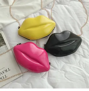 Lip-shaped crossbody bags in yellow, black and pink with gold chain straps shown on white sheet