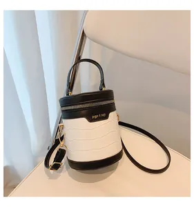 Details der Krokodilstruktur an der kontrastreichen zylindrischen Tasche mit Gold-Zipper