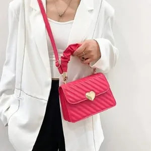 Detail of rose pink quilted crossbody bag with heart buckle and pleated handle