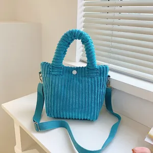 Detailed close-up of sky blue corduroy bucket bag with handle and adjustable strap