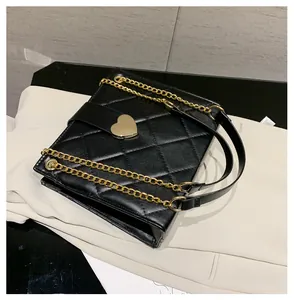 Détail du sac bandoulière en cuir PU matelassé noir avec fermoir en métal doré en cœur
