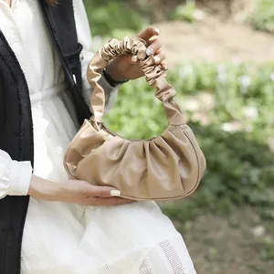 Detalle de bolso nube beige con pliegues suaves de cuero sintético y asa fruncida