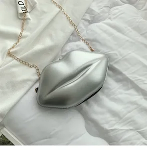 Detail of silver lip-shaped mini crossbody bag with metallic PU finish and golden chain
