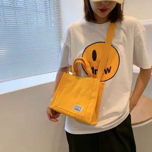 Fashion yellow canvas tote bag shown worn as a crossbody bag on female model