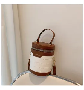 Detail der zylindrischen Tasche mit weißem Krokodilmuster und braunem Leder-Farbmix