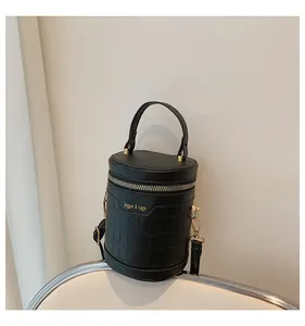 Detailansicht der schwarzen Zylindertasche mit Kroko-Prägung und goldenem Reißverschluss