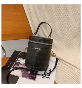 Details der schwarzen Zylindertasche mit Krokoprägung und goldenen Beschlägen
