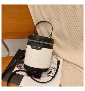 Makro-Detail der Zylindertasche mit Krokostruktur und kontrastierendem Farbdesign