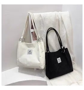Detailed view of corduroy tote bags with leaf patch and silver metal ring strap connectors