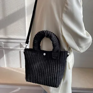 Chic black corduroy tote bag with textured handle and button closure for women