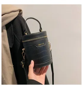 Details der schwarzen Zylindertasche mit Krokodilmuster und goldener Hardware