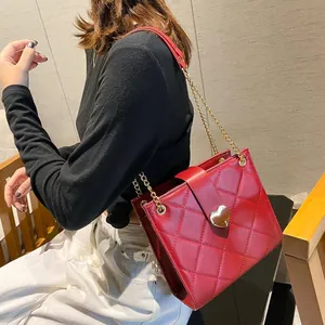 Sac à bandoulière matelassé rouge avec fermoir cœur doré et bandoulière en chaîne