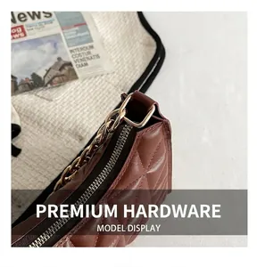 Detail of brown quilted leather texture and premium gold chain hardware on a small bag