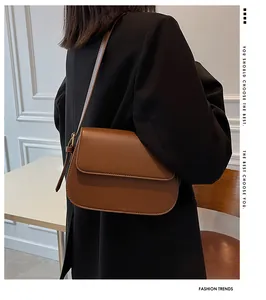 Detailed side view of a brown semi-circular saddle bag with adjustable strap on model