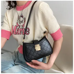Détail du sac à bandoulière matelassé noir avec boucle dorée et texture en cuir PU