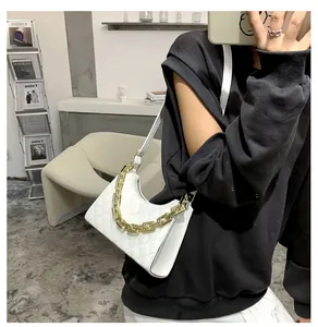 Détail du sac demi-lune matelassé blanc avec chaîne dorée et bandoulière en cuir