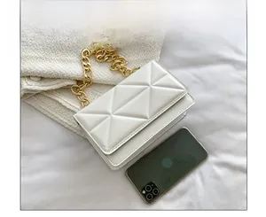 Size comparison of white quilted chain bag showing geometric texture next to a smartphone