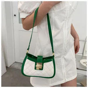 Détail du sac bandoulière blanc et vert avec boucle dorée et cuir au fini matelassé