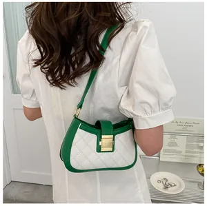 Détail du sac à bandoulière bicolore blanc et vert avec fermoir doré et texture matelassée
