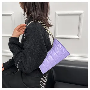 Close-up of purple quilted underarm bag with decorative gold chain strap and PU texture