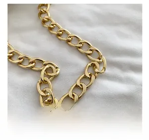 Detailed view of glossy gold metal chain strap with thick oval links for small handbags