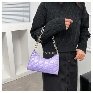 Detail showing lavender purple quilted shoulder bag with thick gold metal chain strap