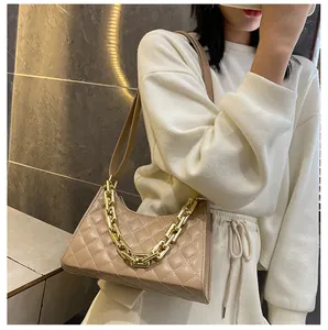 Gros plan du sac bandoulière beige en similicuir matelassé avec détail chaîne dorée chic