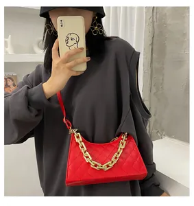 Détail d'un sac bandoulière rouge matelassé avec chaîne dorée et longue bandoulière