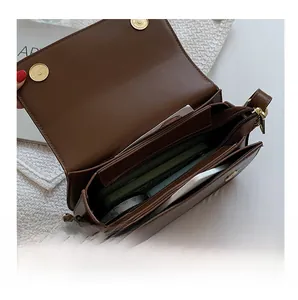 Top-down view of coffee brown saddle bag interior showing multiple compartments and zipper
