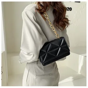 Detail of black crossbody bag with geometric quilting and golden chunky chain strap