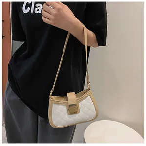 Détail du sac baguette blanc matelassé avec boucle dorée sur un mannequin