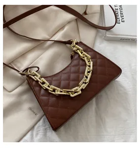 Détails du matelassage et de la chaîne dorée sur le sac bandoulière en cuir marron