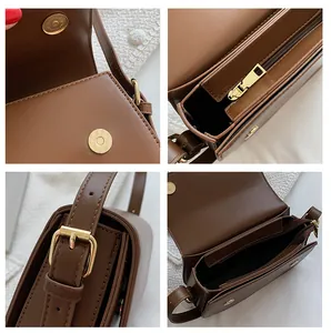 Detail view of dark brown faux leather bag with gold hardware and multiple compartments
