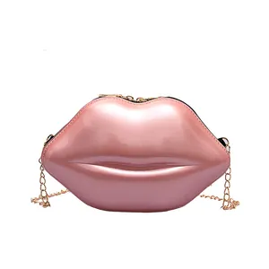 Pink pearlescent lip-shaped mini crossbody bag with gold chain strap on white background